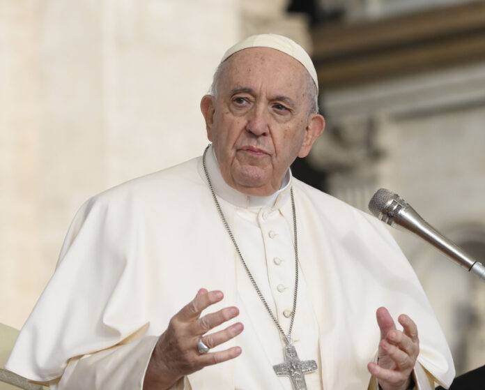 Papa Francesco a mezzo busto parla al microfono