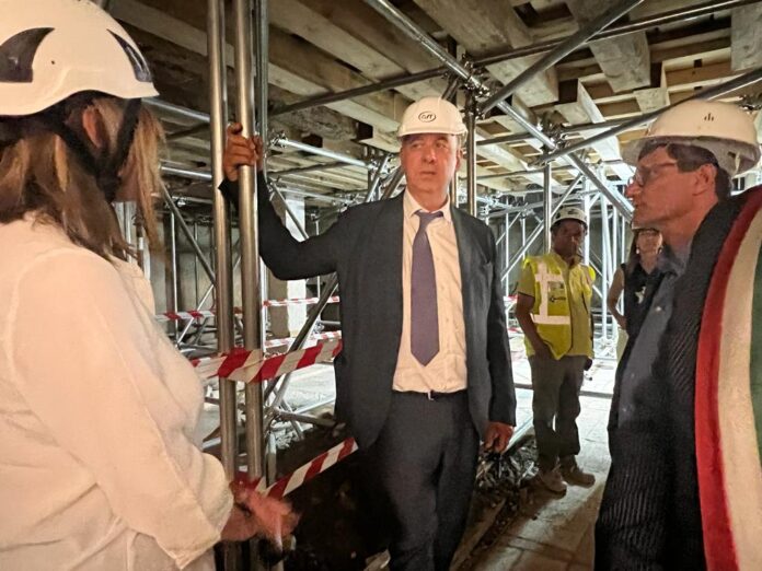 Il commissario Legnini all'interno del cantiere della basilica di San Benedetto di Norcia insieme ad altre persone