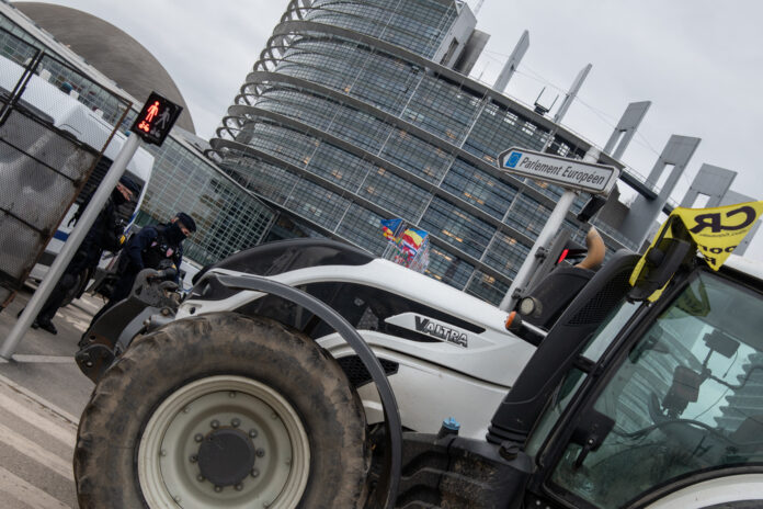 Un trattore in primo piano davanti al parlamento europeo di Strasburgo