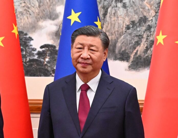 Xi Ginpin a mezzo busto alle spalle le bandiere dell'Europa e della Cina