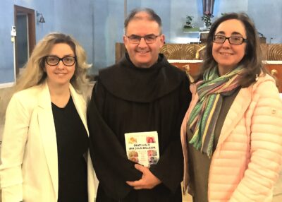 A sinistra Erika Fossati, con la giacca gialla e i capelli lunghi biondi, con gli occhiali, padre massimo Reschiglian, con la veste francescana e Maria letizia Tomassoni, con i capelli lunghi scuri e gli occhiali, la giacca color senape