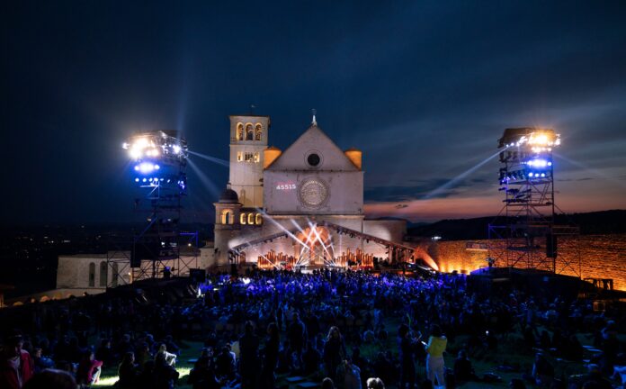 La basilica superiore di San Francesco ad Assisi di notte, davanti al sagrato il concerto