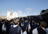 pellegrini di spalle sullo sfondo la basilica superiore di San Francesco ad Assisi