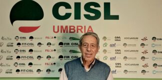 Luigi Fabiani a mezzo busto sullo sfondo il manifesto della Cisl Umbria