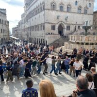 I giovani con i frati francescani in piazza IV Novembre intorno alla Fonta aMaggiore, sullo sfondo Palazzo dei Priori