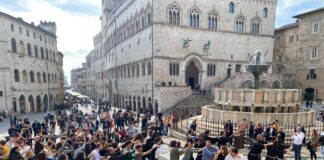 I giovani con i frati francescani in piazza IV Novembre intorno alla Fonta aMaggiore, sullo sfondo Palazzo dei Priori