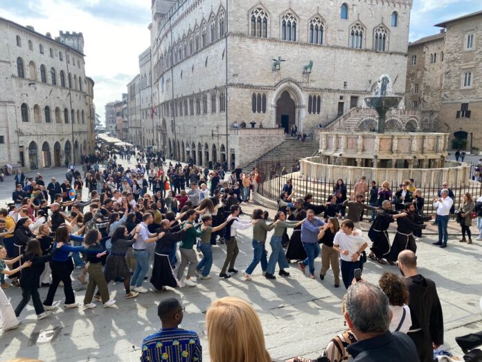 I giovani con i frati francescani in piazza IV Novembre intorno alla Fonta aMaggiore, sullo sfondo Palazzo dei Priori