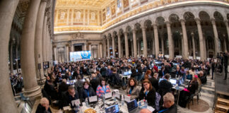 I sinodali seduti ai tavoli all'interno della basilica di San palo fuori le mura