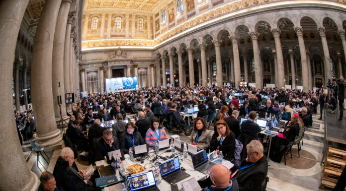 I sinodali seduti ai tavoli all'interno della basilica di San palo fuori le mura