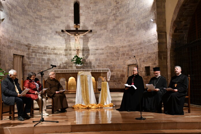 I vescovi e i rappresentanti delle chiese cristiane presenti in Umbria sul presbiterio del santuario della Spogliazione disposti a semicerchio al centro l'evangelario, sullo sfondo il crocifisso e l'altare