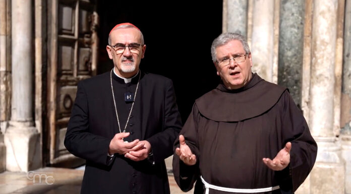 Il Patriarca Pizzaballa in veste nera con la croce pettorale e lo zucchetto rosso cardinale; ha occhiali e barba bianca. Accanto padre Francesco Patton in abito francescano marrone